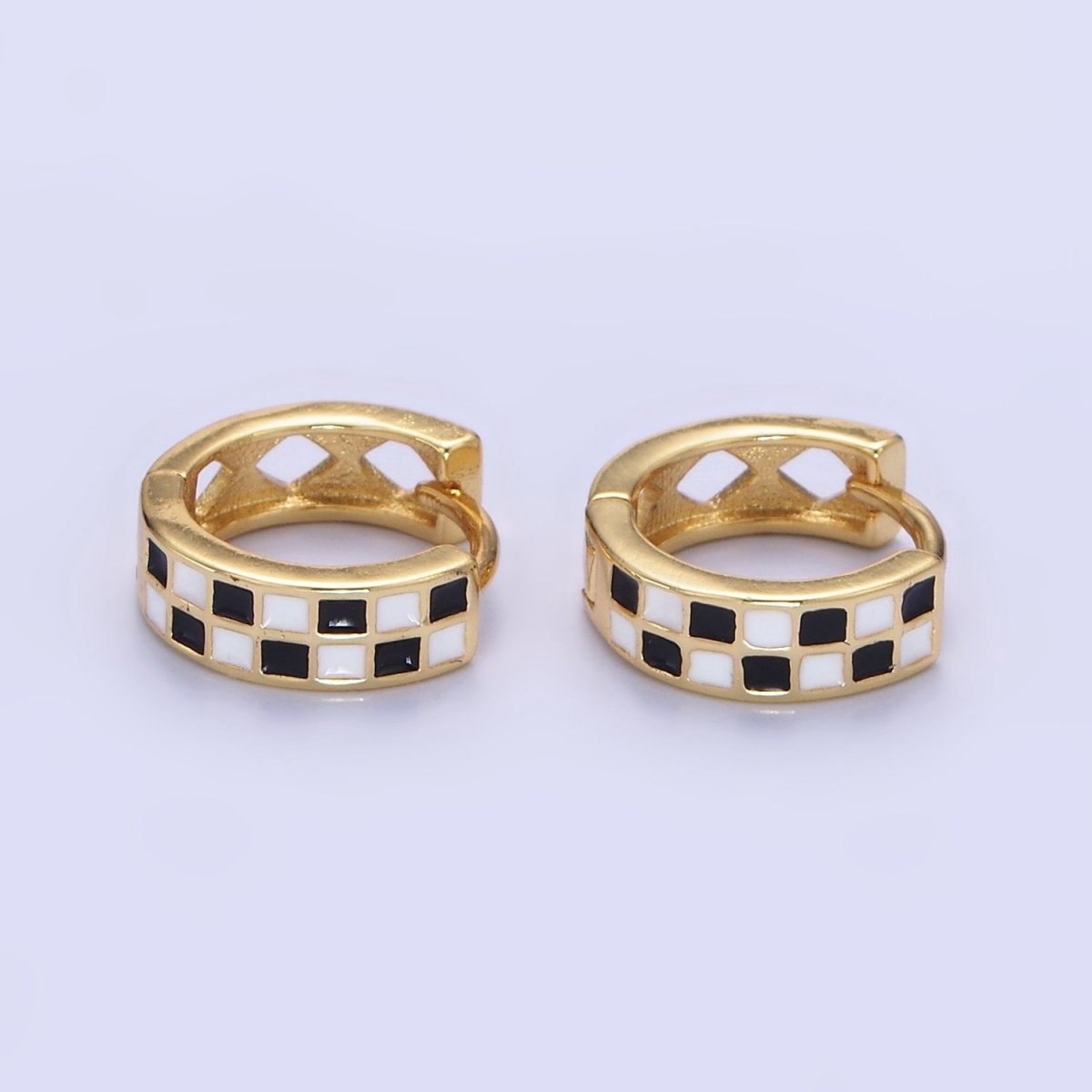 Pair of gold hoop earrings with black and white checkered pattern on a light gray background
