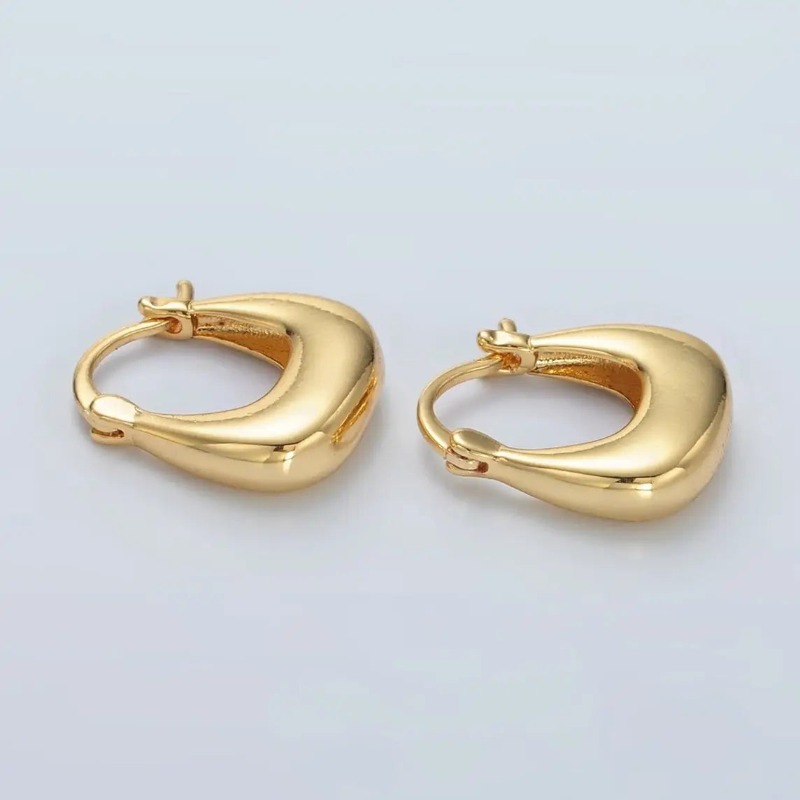Pair of gold hoop earrings on a light gray background