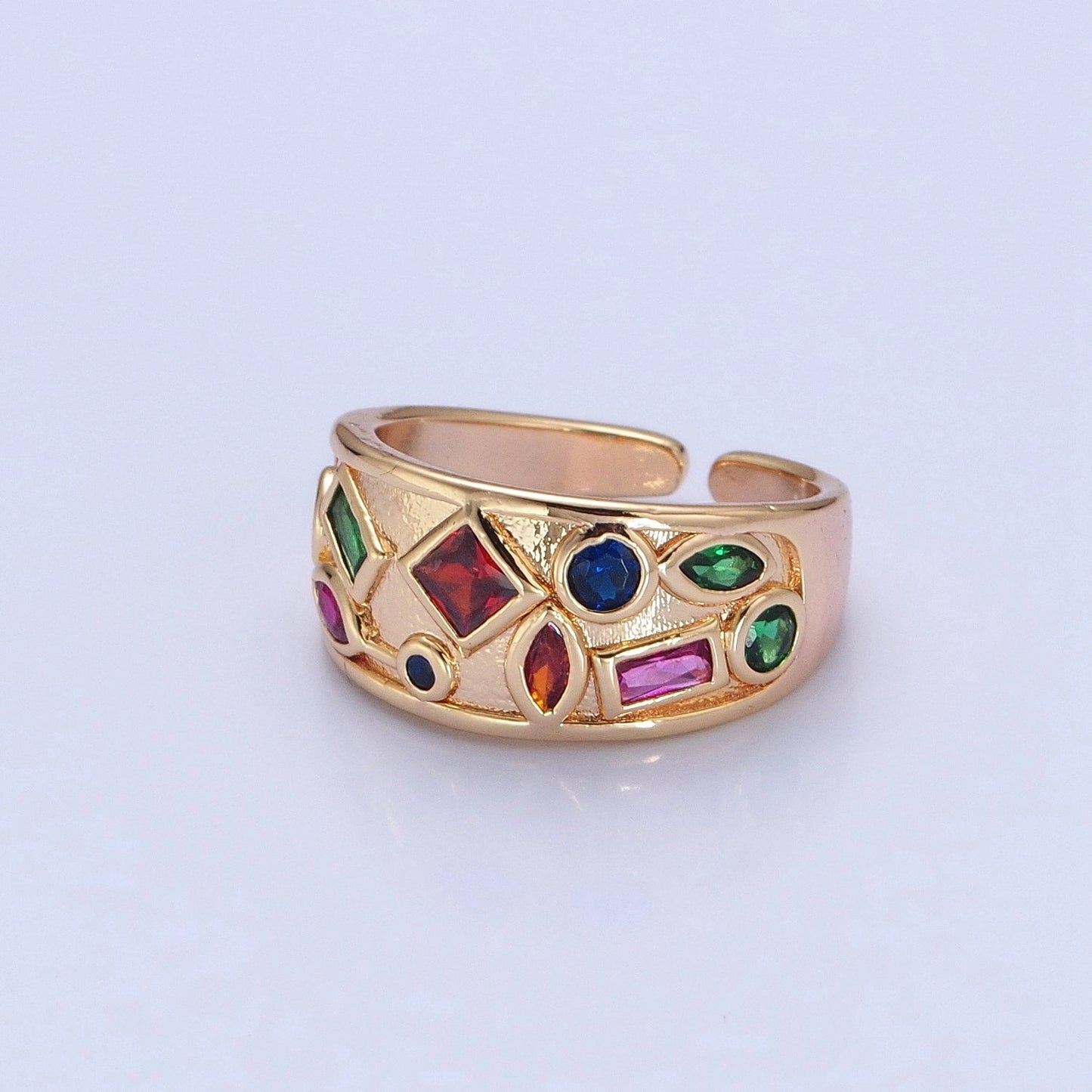 Gold ring with colorful gemstones on a light gray background